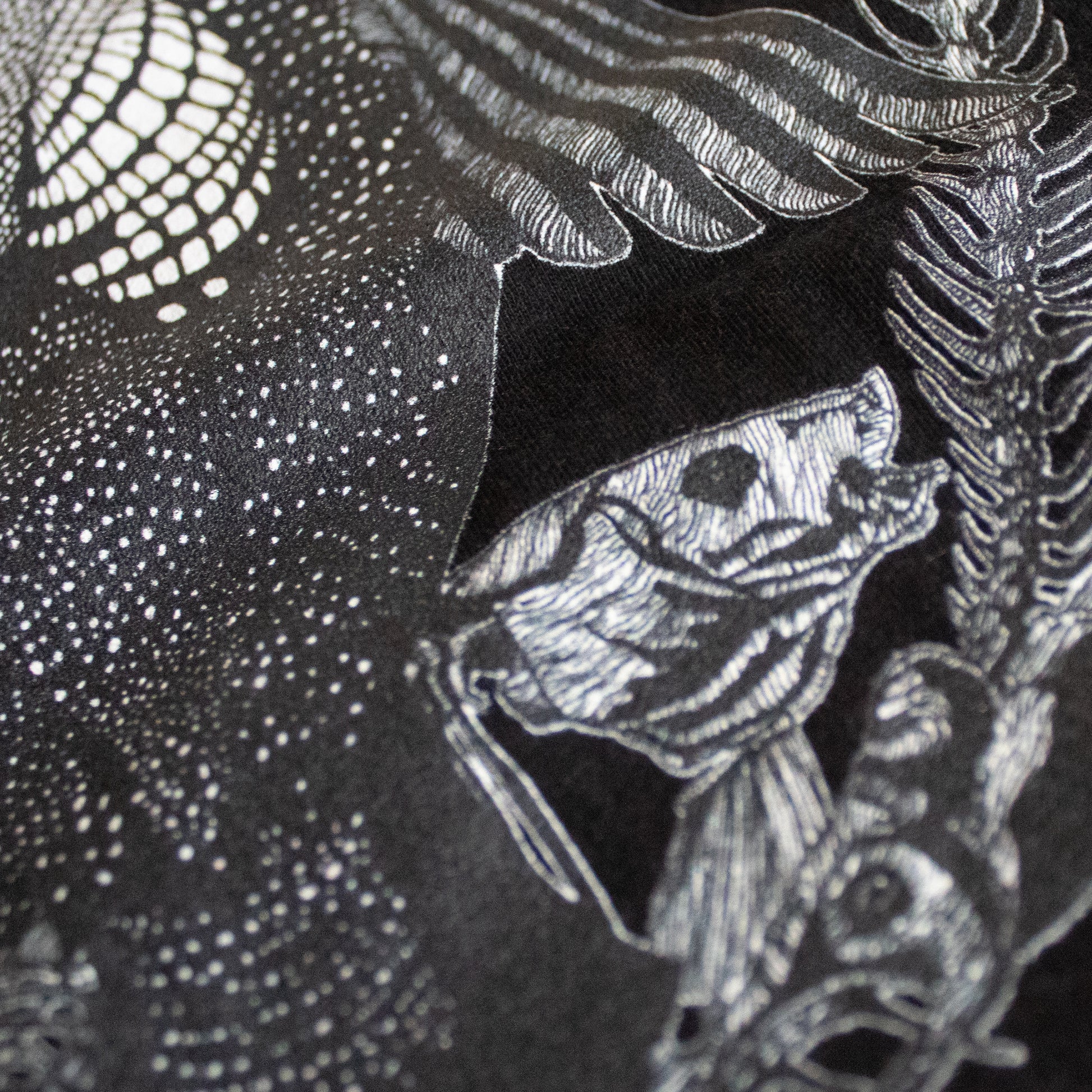 Close-up on black and white, tattoo inspired, gothic, witchy, pagan art on clothing piece. Birds & Bones collection features nature and death inspired artwork on t-shirts and sweathirts.